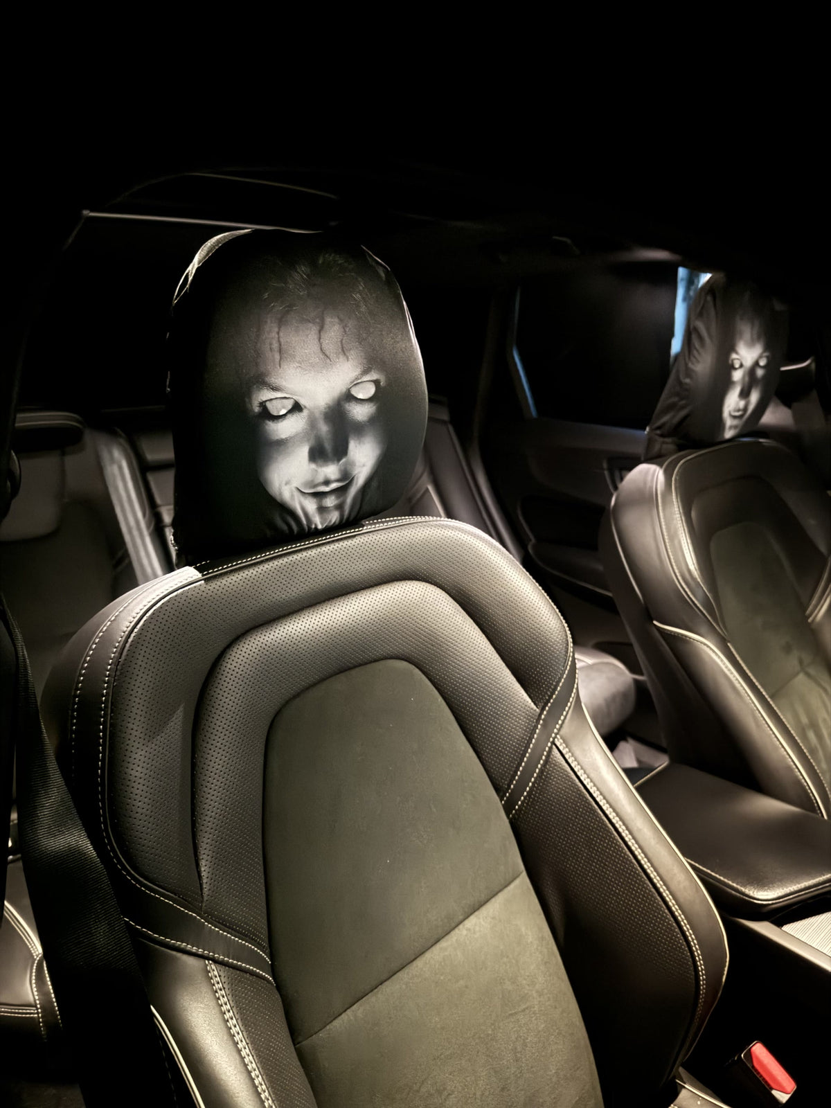 Two PhantomSeat ghost headrest covers on both front seats of a car at night