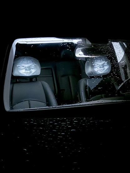 Ghost faces visible through the windshield from outside the car